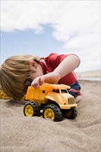 Boy playing with truck in sand
