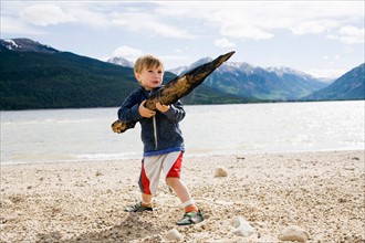 Boy (2-3) holding piece of wood