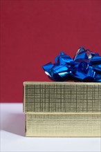 Studio shot of gift with blue bow on red background