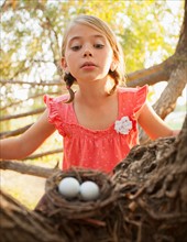 Little girl (6-7) looking at bird's nest