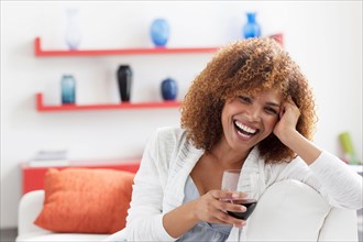 Mid adult woman relaxing at home with glass of wine