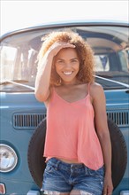 Portrait of smiling woman standing in front of van
