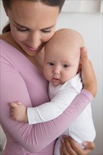 Mother holding baby daughter (6-11 months)