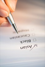 Close-up of hand filling out form.