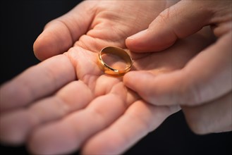 Hand holding wedding ring.