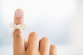 Hand with reminder bow on finger.