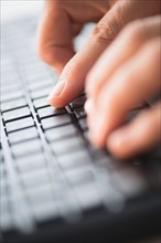 Close-up of hands typing on keyboard.