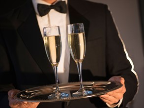 Waiter holding tray with champagne.