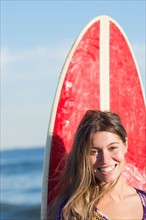 Portrait of woman with surfboard. Photo : Jamie Grill