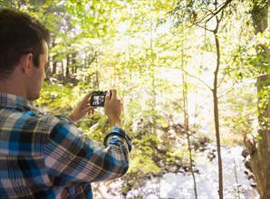 Man taking picture in forest. Photo : Jamie Grill