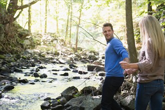 Couple walking by stream in forest. Photo : Jamie Grill