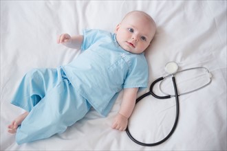 Portrait of baby boy (2-5 months) with stethoscope. Photo : Jamie Grill