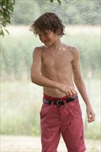 Boy (10-11) playing with splashing water. Photo: pauline st.denis