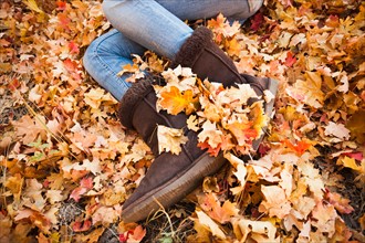 Legs of young woman lying on autumn leaves. Photo : Mike Kemp