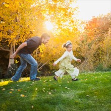 Bountiful, Family with two daughters (2-3, 4-5) playing in garden . Photo: Mike Kemp