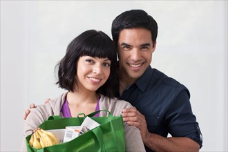 Portrait of young couple with shopping bag. Photo: Dan Bannister
