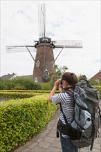 Woman photographing windmill. Photo : Jan Scherders