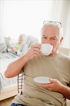 Senior man having morning cup of coffee. Photo : Rob Lewine