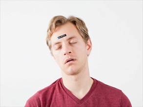 Sleeping man with sticker on his forehead. Photo: Jessica Peterson