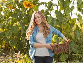 Portrait of young woman harvesting sunflowers. Photo : Jessica Peterson