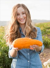 Portrait of young woman holding squash. Photo: Jessica Peterson