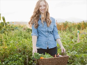 Portrait of young woman harvesting vegetables. Photo : Jessica Peterson