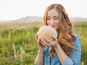 Portrait of young woman holding cantaloupe. Photo: Jessica Peterson