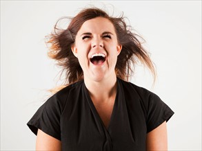 Studio portrait of young woman screaming. Photo : Jessica Peterson