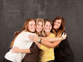 Studio portrait of four women embracing. Photo : Jessica Peterson