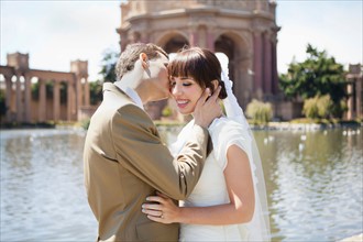 Groom kissing bride in park. Photo: Jessica Peterson
