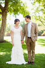 Bride and groom strolling in park. Photo: Jessica Peterson