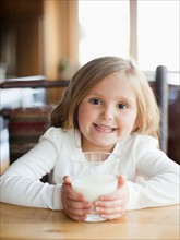 Girl (4-5) drinking milk in kitchen. Photo : Jessica Peterson