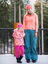 Portrait of mother and daughter (4-5) standing outdoors. Photo : Jessica Peterson
