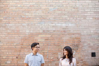 Couple standing in front of brick wall. Photo : Jessica Peterson