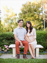 Portrait of couple sitting on bench in park. Photo : Jessica Peterson