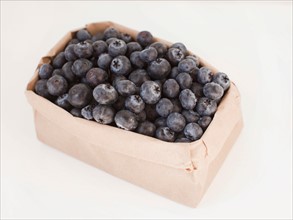 Carton of blueberries on white background. Photo : Jessica Peterson