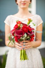 Mid section of bride with bouquet in focus. Photo : Jessica Peterson