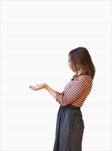 Studio shot young woman bending over backwards pretending like holding something. Photo: Jessica