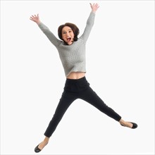 Studio portrait of mid adult woman jumping.