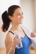 Woman drinking water in gym.