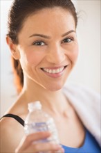Portrait of woman drinking water in gym.