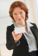 Portrait of businesswoman holding blank business card.