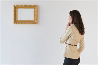 Woman looking at blank picture in art gallery.