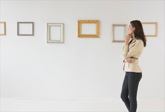 Woman looking at blank pictures in art gallery.