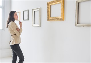 Woman looking at blank pictures in art gallery.
