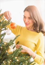 Woman decorating christmas tree.