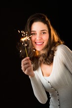 Woman holding sparkler.