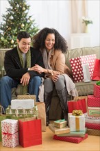 Couple with Christmas presents in living room.