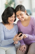 Grandmother and granddaughter (16-17) with mobile phone.
