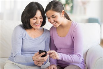 Grandmother and granddaughter (16-17) with mobile phone.